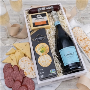 Gourmet cheese, crackers, chocolate, cookies and a bottle of La Marca Prosecco in a wooden crate.