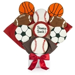 Bouquet of sugar cookies shaped and decorated like basketballs, footballs, soccer balls, and basketballs with customized text on one cookie.