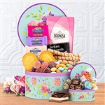 Round gift box decorated with pastel flowers for spring filled with cakes, cookies and chocolate.